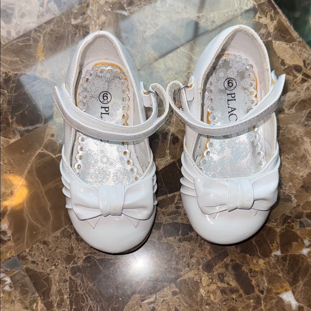 Size 6 baby girls white dress shoes. Velcro strap across foot, heeled.
